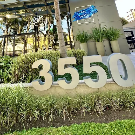 O número 3550 em letras grandes no jardim, diante da entrada do prédio Van Gogh Offices
